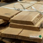 Kiln-dried unedged acacia boards stacked together in a warehouse setting