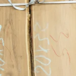 Acacia wood grain texture on unedged board surface with chalk markings
