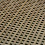 Close-up of the oak grille's diagonal lattice weave, showing wood grain through the crossed slats.