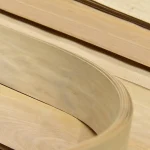 Close-up of a curved sheet of 0.6 mm Anegre sliced veneer showing its grain.