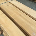 Texture of premium grade edged acacia lumber boards stacked on a pallet.