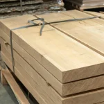 Kiln-dried edged acacia boards stacked on a warehouse pallet