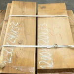 Texture of grade 1 edged acacia lumber board bundle in a warehouse.