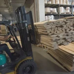 Selecting acacia boards in the warehouse using a forklift loader.