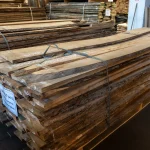 Wholesale supply of 52 mm unedged elm boards stacked on pallets in a warehouse