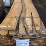 Long 52 mm unedged elm boards of extra grade stacked in a warehouse