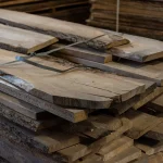 Thickness of grade 1, 52 mm unedged elm boards stacked in a warehouse