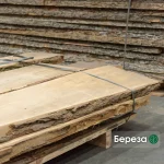 A stack of premium unedged birch boards of Extra grade bound together, showcasing natural bark edges.