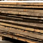 Unedged 52 mm beech timber boards stacked neatly in a warehouse.