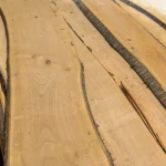 Natural curves and wood grain texture of unedged cherry lumber boards.