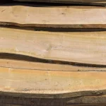 Detailed view of annual rings and wood fibers on unedged cherry boards.
