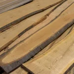 Unedged cherry wood boards stacked at an angle to showcase their natural edges.