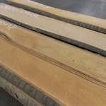 Several unedged cherry boards laid out flat with chalk-marked dimensions.
