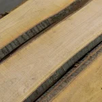 Detailed view of the bark edge and fine wood grain of unedged cherry boards.