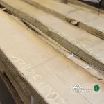 Close-up of unedged red oak boards with chalk measurements showing the wood grain and natural edge.