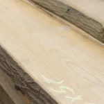 Angled close-up of a red oak unedged board highlighting its beautiful grain pattern and natural edge.