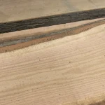 Detailed texture of red oak wood grain on a premium unedged board.