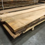 Side view of a stack of extra grade unedged red oak boards on a pallet.