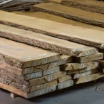 Stack of dry 52 mm Extra grade unedged oak boards in a warehouse setting