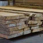 Unedged oak boards of extra grade, 52 mm, 1 to 4.5 meters long, stacked in a warehouse.