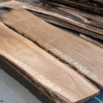 Length of a 52 mm unedged European walnut board with size markings in a warehouse.