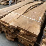 Width of 52 mm European walnut unedged boards stacked on a pallet in a warehouse.