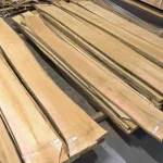 High-angle view of a large batch of unedged maple boards stacked in a woodworking warehouse.