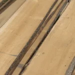Diagonal view of unedged maple boards highlighting the rustic bark edges and clean wood surface.