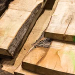 Close-up of the ends and surfaces of unedged linden boards with natural bark.
