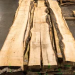 Top-down view of long unedged linden boards laid out on a stack.