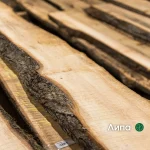 Close-up of an extra grade unedged linden board showing its natural bark edge and light wood texture.