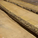 Вид сбоку на необрезные доски бархата амурского с выраженной натуральной корой.