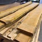 Several unedged Amur corktree boards of extra grade laid out in a warehouse.