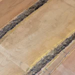 Top-down view of the wood grain and bark edges of two parallel unedged boards.