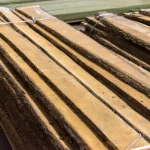 Neatly stacked and strapped unedged alder boards ready for transport.