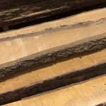 Surface texture of unedged alder boards showing the warm golden-brown wood grain.