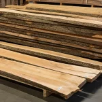 Large stack of premium unedged ash boards stored on a pallet in a woodworking warehouse.