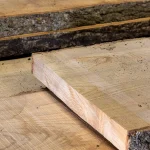 Close-up of the end cut and face grain of a high-quality unedged ash board.