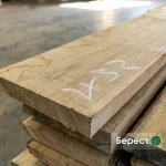 Dry edged elm board stacked in a warehouse setting