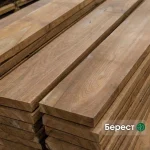 Kiln-dried 52 mm edged elm boards of first grade stacked in a warehouse.