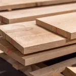 Stacked edged cherry boards with red markings on the ends, highlighting the precise cut and thickness.