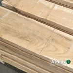 Close-up of stacked red oak edged lumber boards showing natural wood grain.