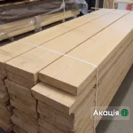 A neat stack of strapped edged red oak boards showing clean surfaces and edges.