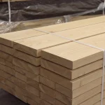 Side view of a neatly stacked bundle of extra grade red oak lumber boards.