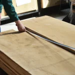 Measuring the length of a premium extra grade edged oak board, 52 mm, with a tape measure.