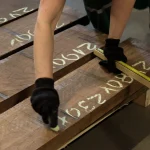 Measuring the dimensions of American walnut boards, 54 mm, in a warehouse