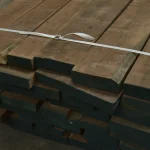 Width of black American walnut boards 52 mm packed in a stack on a warehouse floor.