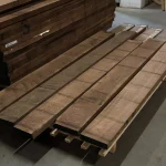 Edged American walnut boards, 52 mm, laid out on a pallet in a warehouse setting.