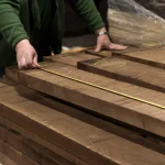 Measuring the length of a 52 mm American walnut edged board with a tape measure.