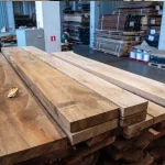 Kiln dried European walnut edged boards with thicknesses of 32 and 52 mm stacked in a warehouse
